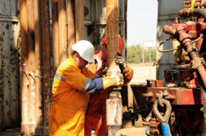 drilling rig workers in orange uniform